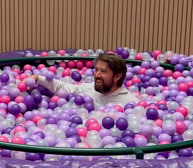 Mike Terhar in a ball pit wearing a business shirt